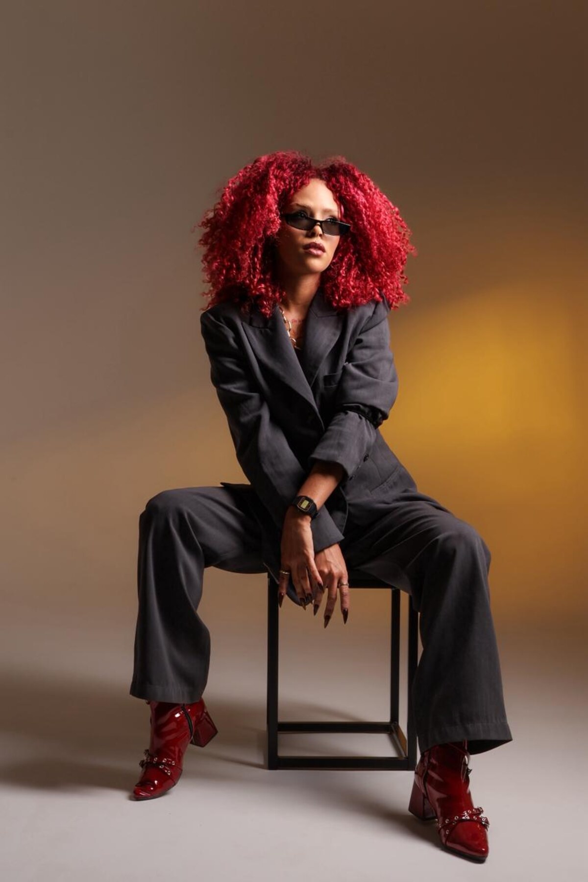 BUSINESS SERVING, pose sentada com salto vermelho