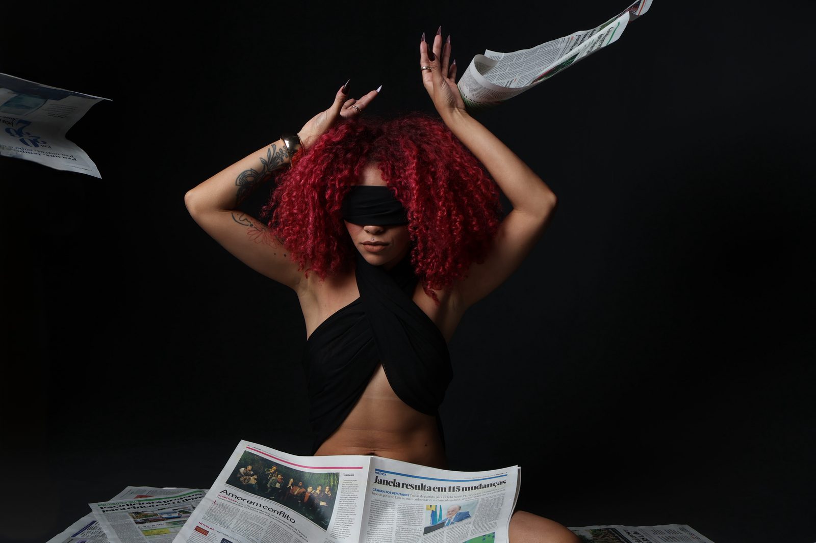 VERLEUGNUNG, retrato entre folhas de jornal em queda
